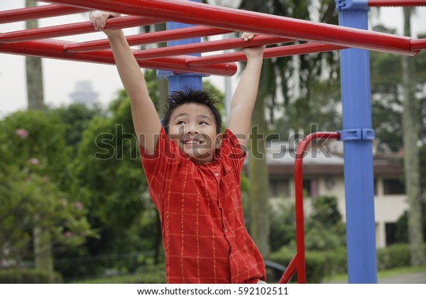 Boy using the jungle\
gym at playground