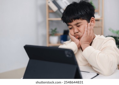 Boy using tablet for learning and stressed about online learning, Virtual internet online class from school teacher by remote meeting, Homeschooling and education concept, online education concept.
