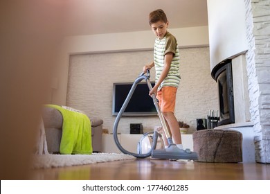 Boy Vacuuming Floor At Home
