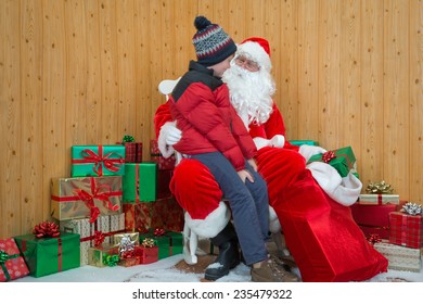 A Boy Visiting Santa In His Grotto At Christmas.