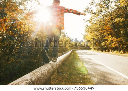 boy walking along the road fence. child keeps balance on the log. copy space for your text Сток-фото © 