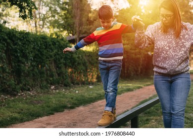 Boy Walking Balance Beam. Mother Holding His Hand.