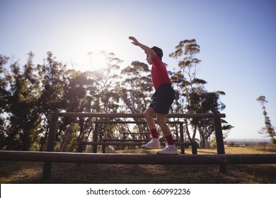 Boy walking on obstacle during obstacle course in boot camp - Powered by Shutterstock