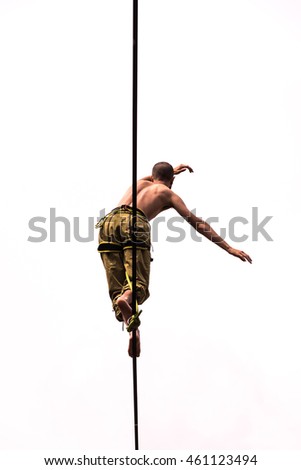 A boy walking on a Slackline/View from below of a guy who practices balancing on tightwire