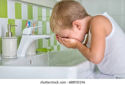  Junge waschen das Gesicht im Badezimmer.Der Anfang eines neuen Tages