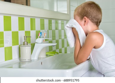 A Boy Washes His Face, Wipes Her Face With A Towel In The Bathroom.