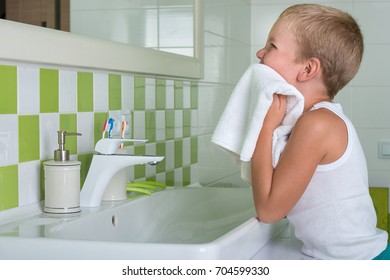 A Boy Washes His Face, Wipes Her Face With A Towel In The Bathroom.