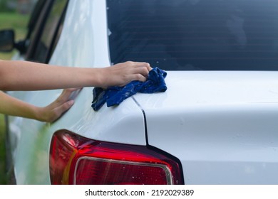 A Boy Washes A White Car With A Rag In The Summer At The Dacha Himself.