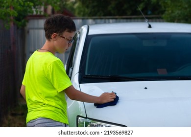 A Boy Washes A White Car With A Rag In The Summer At The Dacha Himself.