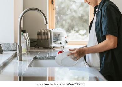 Boy washing dishes, basic house chores - Powered by Shutterstock