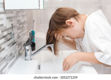 Boy Washing Face In The Bathroom. Morning Hygiene. Preteen Boy Is Washed In A Wash Basin. Healthy Childhood And Lifestyle. Dental Hygiene Every Day. Health Care, Childhood And Dental Hygiene.