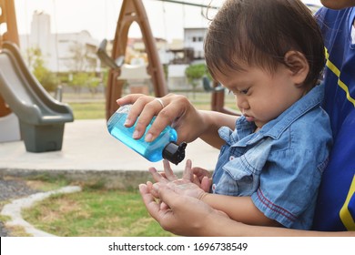 A Boy Washing His Hands With Alcohol Gel Before Playing And After Playing The Equipment Of The Playground,to Kill Germs