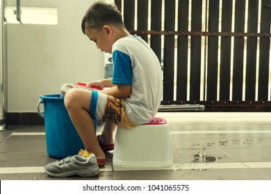 A Boy Washing His School Shoes.