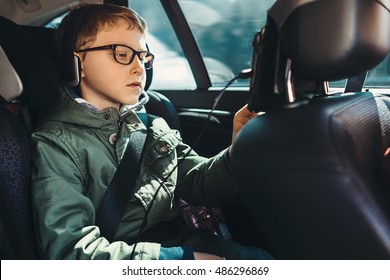 Boy Watch A Tablet On The Car Back Seat 