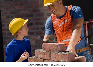 Boy Watching Brick Layer On Construction Site