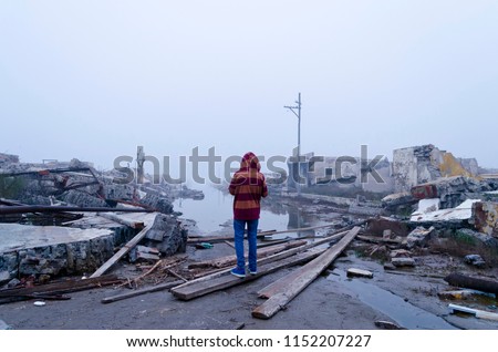 boy watching the flood in Epecuen, Buenos Aires, Argentina. Climate change. Ruins of flooded city.