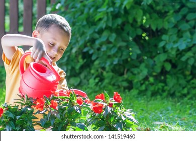 boy with watering can on garden
