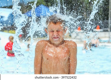 Boy at waterpark being hit with icy cold water