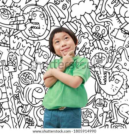 A boy wearing a green polo shirt is thinking creatively over doodle illustration background.