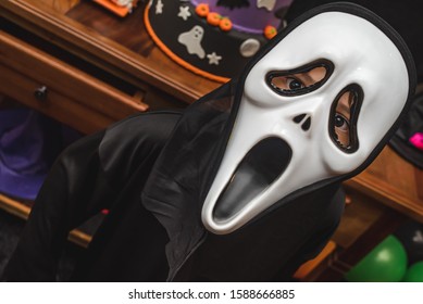 A boy wearing a halloween mask of a ghost