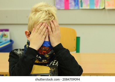 A Boy Wearing A Mask Covering His Eyes, A Sixth Grader In A Classroom.