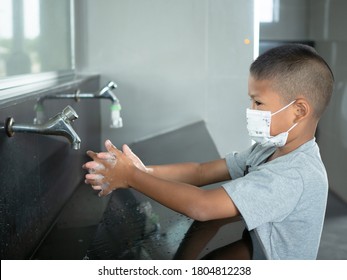 Boy Wearing A Mask Washing Hands In Public Toilets.