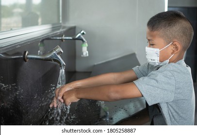 Boy Wearing A Mask Washing Hands In Public Toilets.