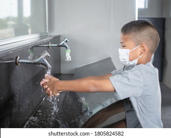 Boy wearing a mask Washing hands in public toilets.