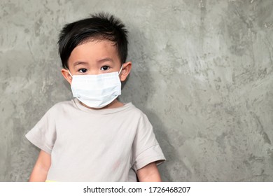 A Boy Wearing Medical Face Mask For Pollution Or Coronavirus,child Itchy Eyes And Nose, Kid Scratching Nose While Wearing Protection Mask.Protection Against Contagious Disease, Coronavirus.