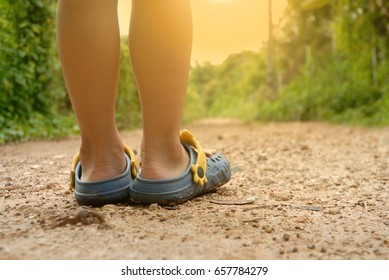 Boy wearing sandals prepare to walk along the dirt road. - Powered by Shutterstock