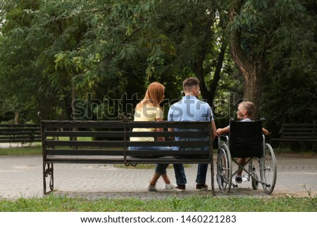 Boy in wheelchair with his family at park