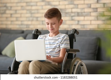 Boy In Wheelchair With Laptop At Home