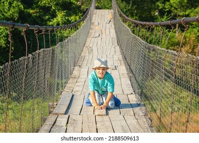 A Boy Who Is Afraid Of Heights Crawls On A Suspension Bridge