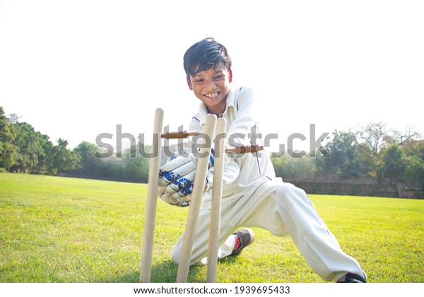 a boy\
wicket keeper stumping during cricket\
game