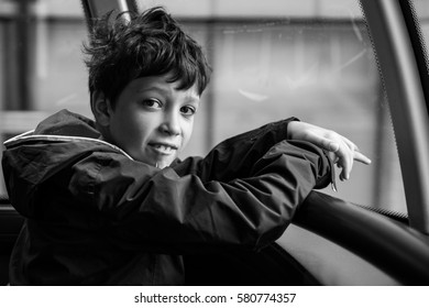 Boy With Wide Eyes In A Bus In London. Traveling And Site Seeing In UK, Holidays In London. Black And White Portrait