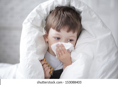 boy wipes his nose with a tissue - Powered by Shutterstock