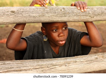 Boy at wooden ranch fence