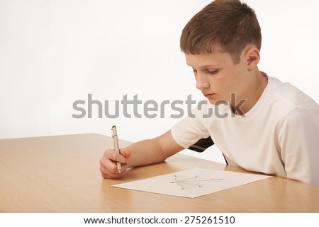 Boy working on an art project sitting at a table