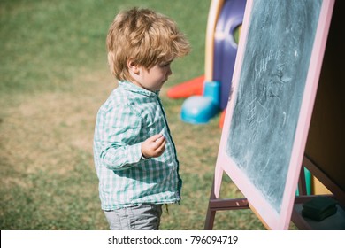 Boy writes chalk blackboard