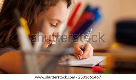 boy writes in a notebook in class. boy at school.