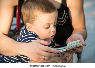 a boy and a young woman playing with a smartphone
