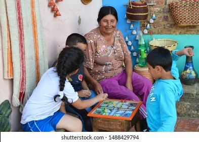 BOYACA, COLOMBIA - JANUARY 23, 2014: A Humble Family Having Some Fun Next To The Church In The Main Square Of Raquira.