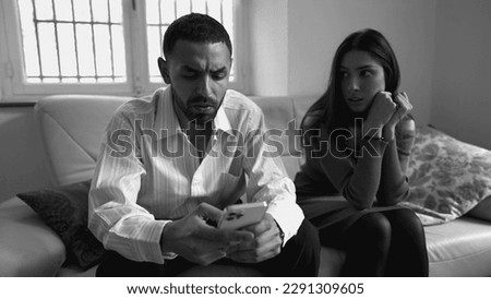 Boyfriend addicted to technology while ignoring girlfriend sitting on couch at home. People obsessed to social media. Loneliness addiction concept