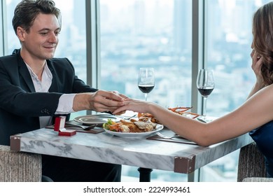 Boyfriend arranges a dinner date with his girlfriend and proposes a wedding ring to his girlfriend at a restaurant.