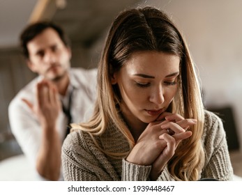 Boyfriend and girlfriend are arguing at home. Angry man is yelling at his sad girlfriend. - Shutterstock ID 1939448467