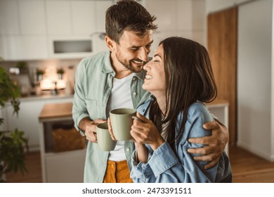 Boyfriend and girlfriend enjoy their first morning coffee at kitchen - Powered by Shutterstock