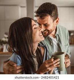 Boyfriend and girlfriend enjoy their first morning coffee at kitchen - Powered by Shutterstock