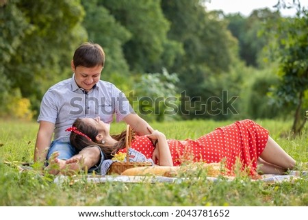 Boyfriend and Girlfriend  Happy Together. Lovers Couple Hug. Happy young Family on Walk in Park Together the Joy on Lawn and they have a Picnic. Love story. Love and Romance between Man and Woman.