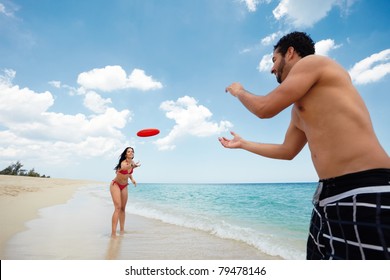 boyfriend and girlfriend playing with frisby on tropical beach. Horizontal shape, copy space - Powered by Shutterstock