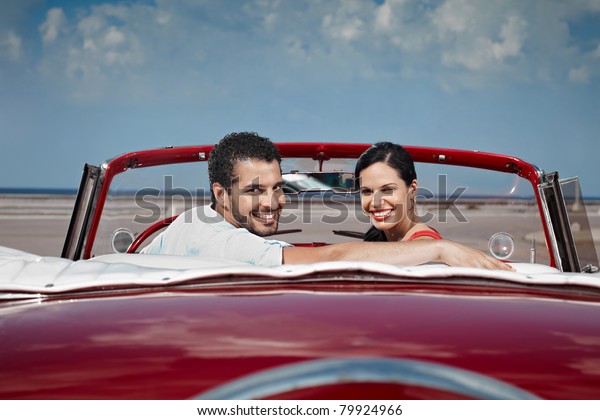 boyfriend and\
girlfriend sitting in vintage car and hugging in havana, cuba.\
Horizontal shape, side view, copy\
space